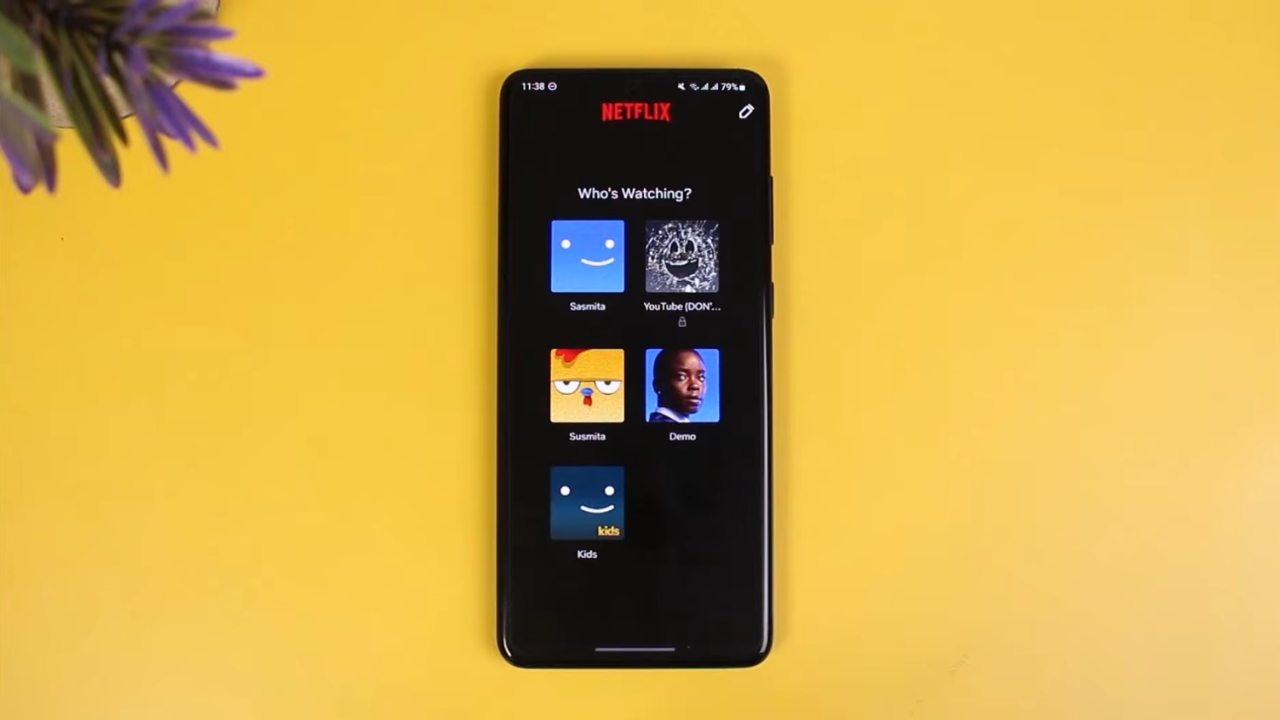 A smartphone displays five Netflix user profiles on a yellow background.