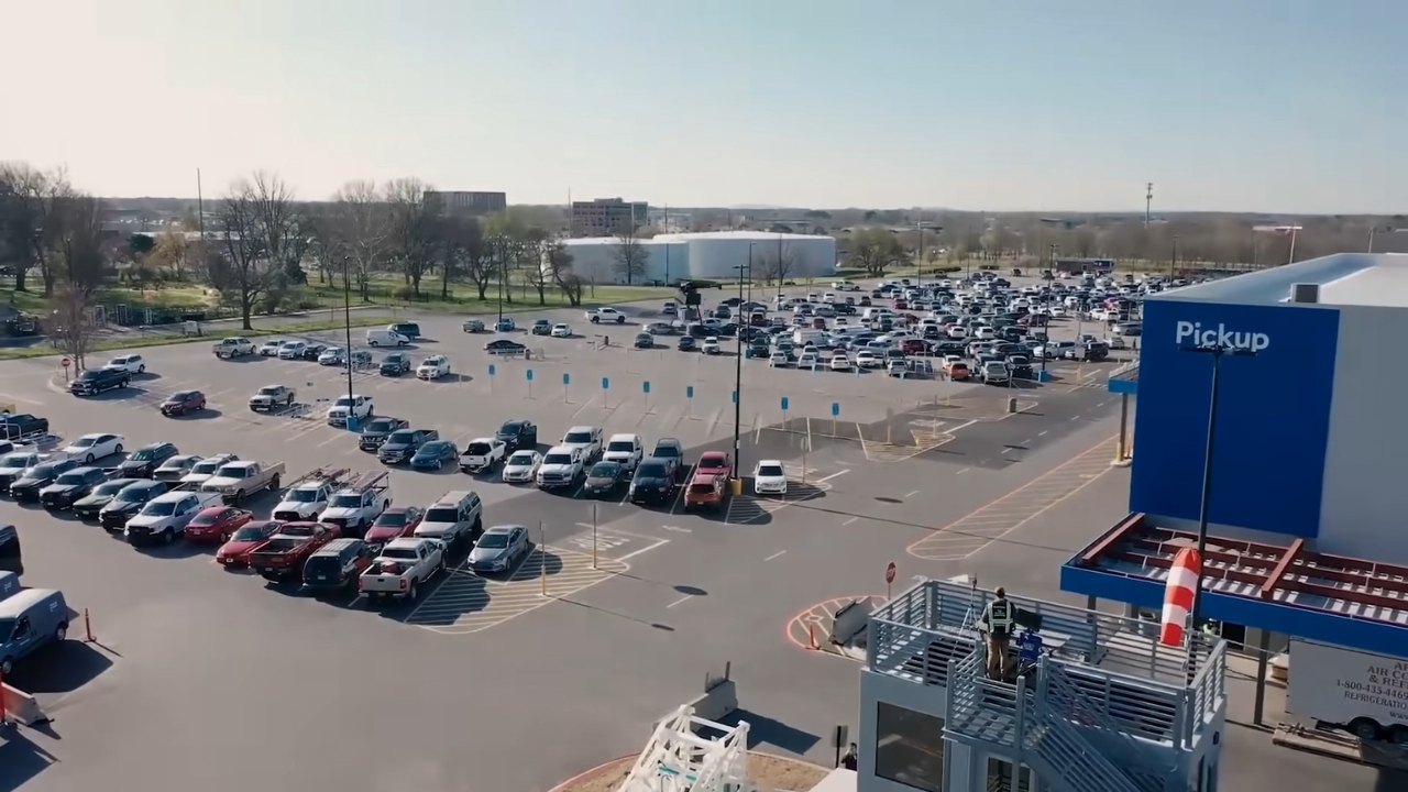 An aerial view of a Walmart parking lot with a drone delivery platform near the pickup area.