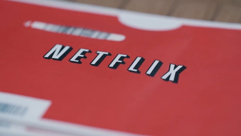 A close-up of Netflix’s logo on its classic red DVD rental envelope.